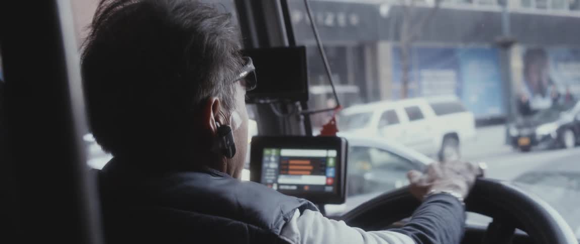 A person driving a bus outdoors