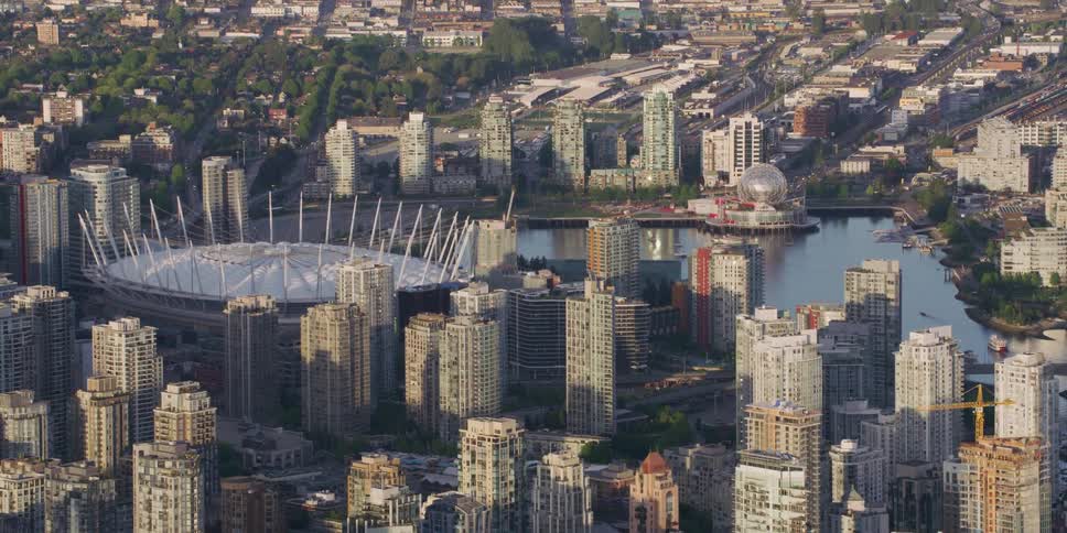 Boats sail in the ocean near a stadium that sits in the heart of downtown