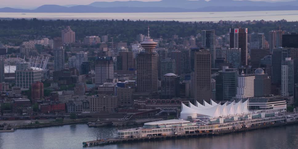 City sits on land bordered on two sides by water with mist mountains in the background
