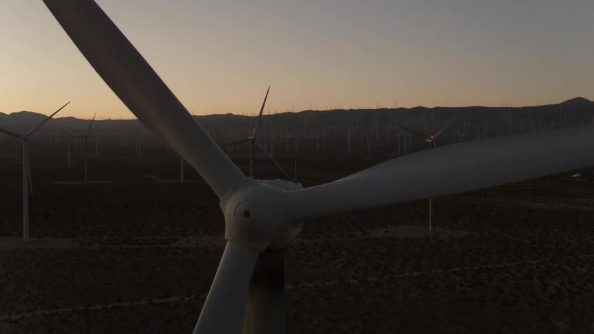 Wind turbines sit not spinning in a field