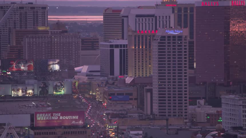 Tourists walking the atlantic city streets as lights flash and glow from billboards hotels and casinos