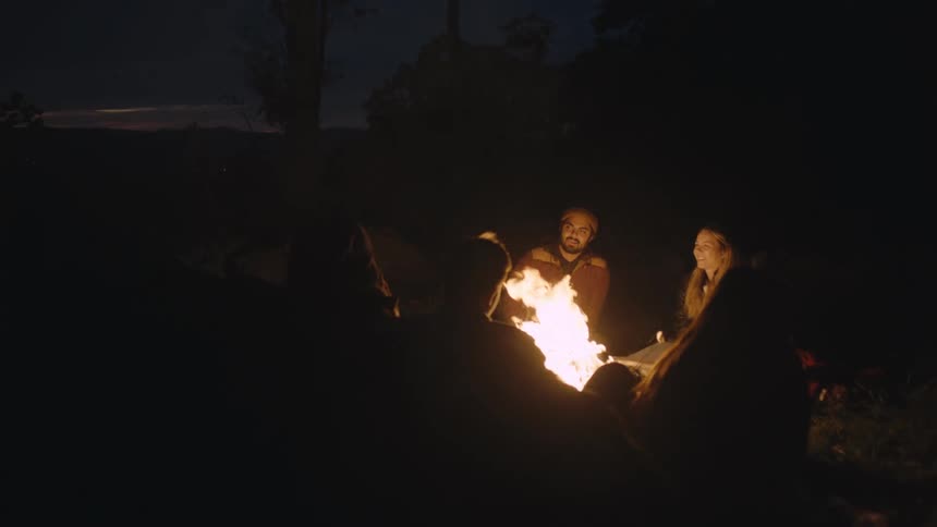 A group of friends sitting around a campfire roasting marshmallows