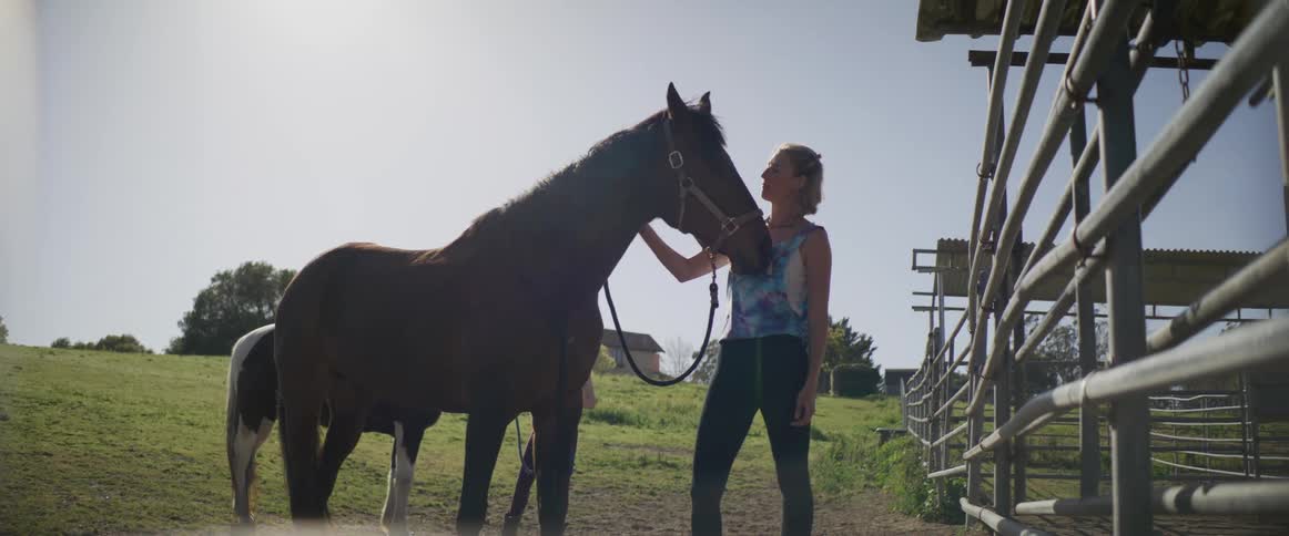 A woman is petting her horse