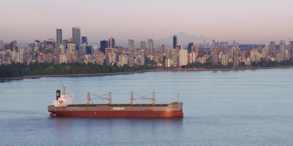 A boat in the ocean in front of a city skyline