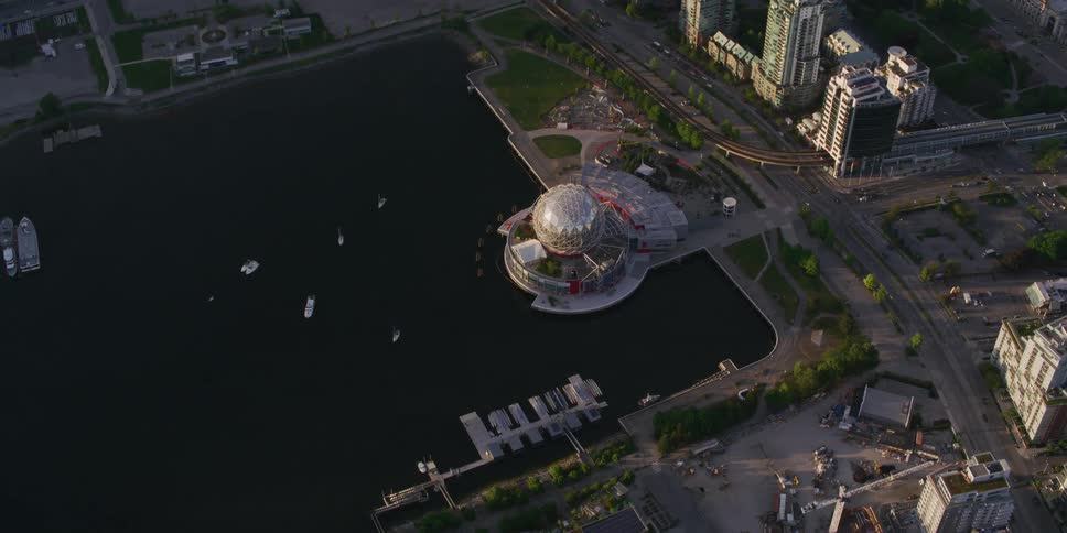 Boats sit in water near elaborate building with unusual architecture and skyscrapers