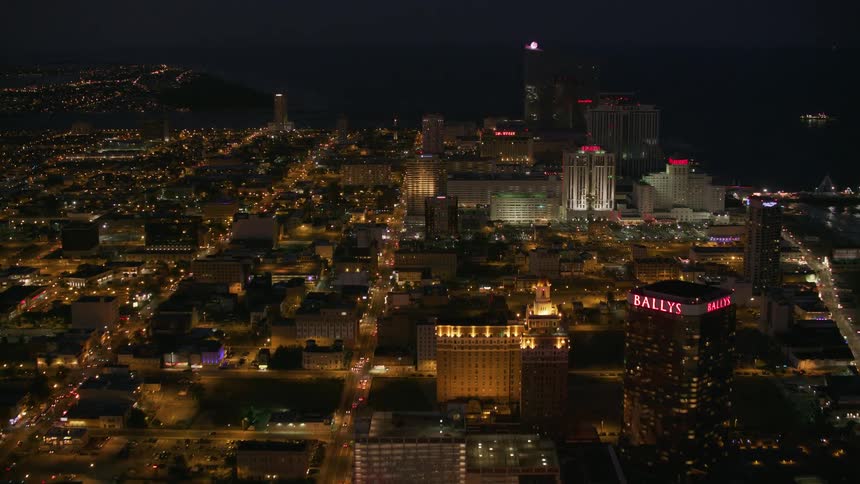 Heavy traffic passes through a city as casino lights shine downtown