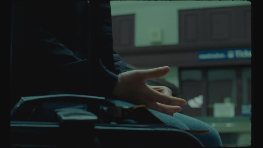 A person sits clasping their hands
