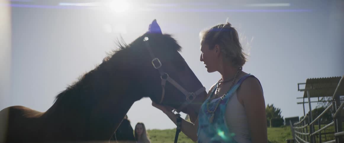 A woman pets her horse
