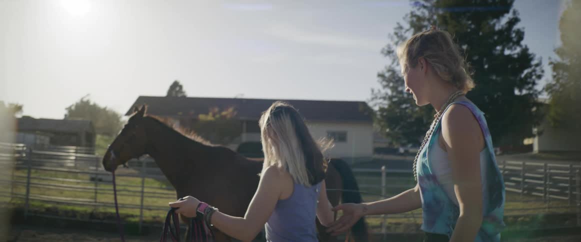 Two women outdoors with a horse