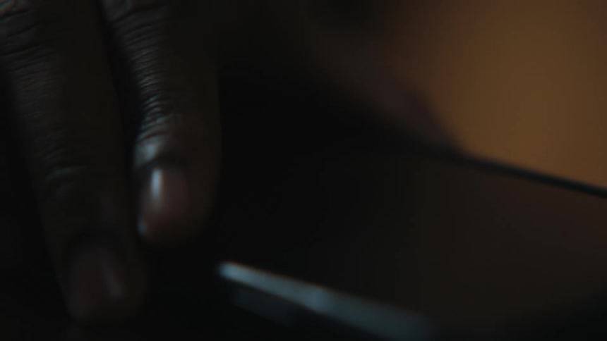 A hand picks up a smartphone then places it back down