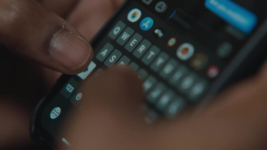 A person is using both thumbs quickly texting on her phone