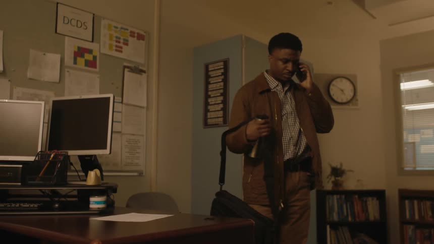 A man enters his office and sits down