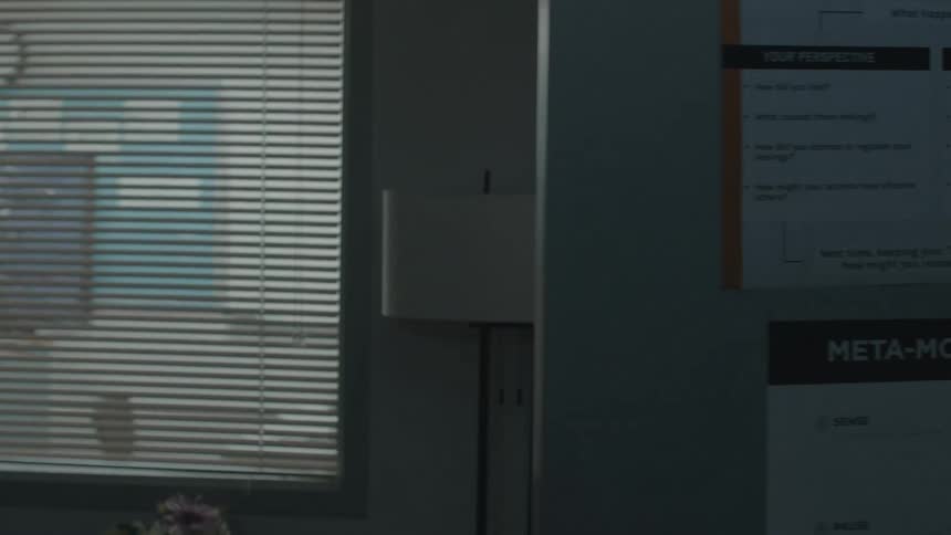 A man talks on his phone and shuts off the lights to his office