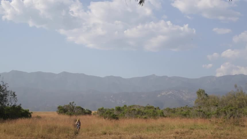 A person is walking over a field in the distance