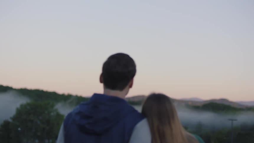A man and woman standing together looking at the horizon