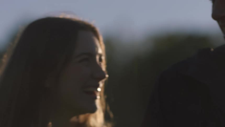 A man and woman laugh together outside