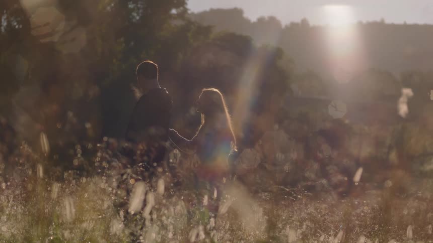A couple share a moment of surprise in a golden field