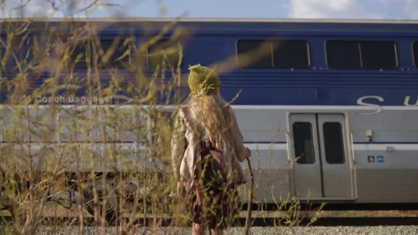 A girl watches as a train passes by