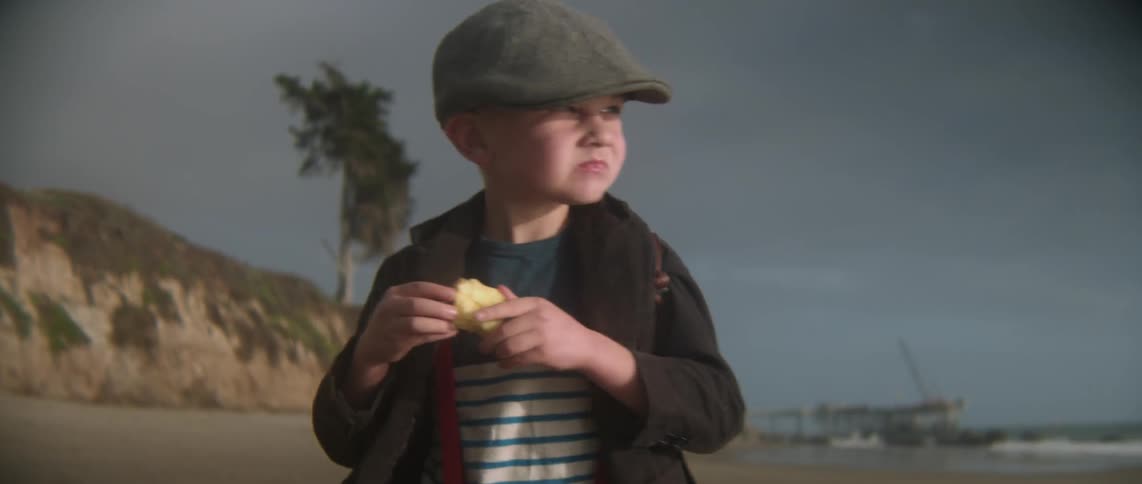 A boy is eating as he walks