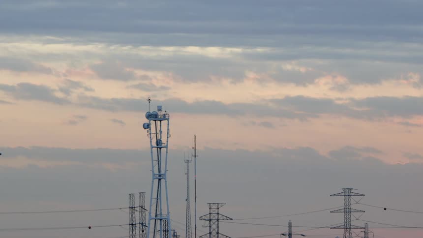 A radio tower blinking near power lines