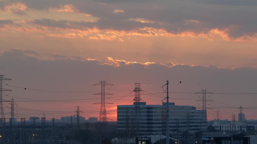 A building sits behind some power lines at sunset