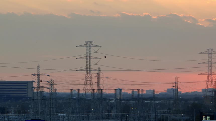 Power lines fill the sky at sunset