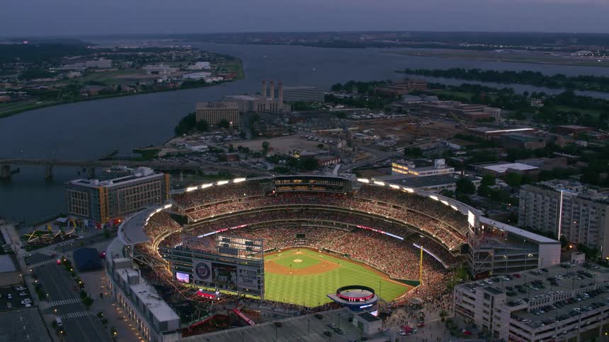 A packaged baseball stadium along the coast is lit up for a night game