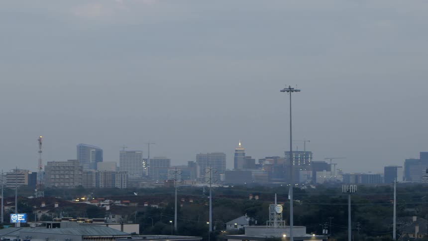 A large city sits in the distance on a cloudy day