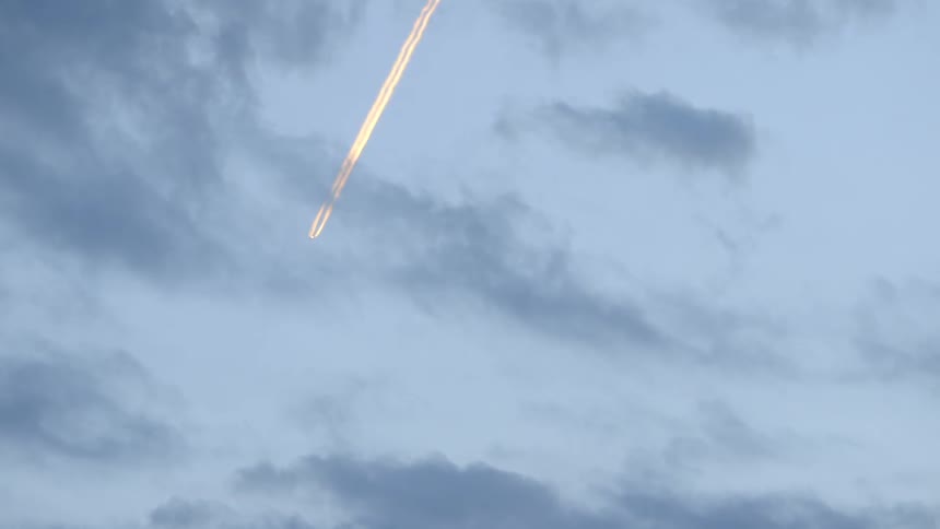 A stream if light moves across a cloudy sky