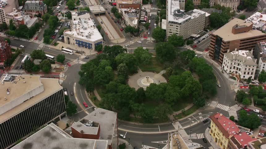 A park in the center of a large roundabout in a metropolis during the day