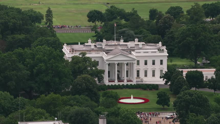 People gathered around the perimeter of the white house during the day