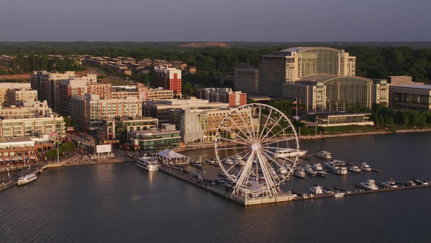 Aerial view of a ferris wheel on a marina in the bay of a small coastal town