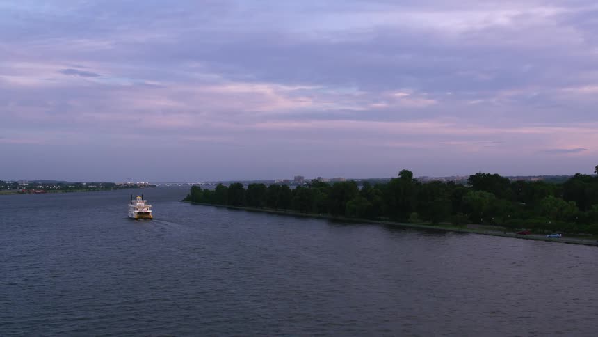 Boats are driving on the body of water at dusk