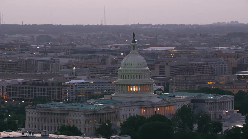The lights in the us capitol building dome glowing at dawn
