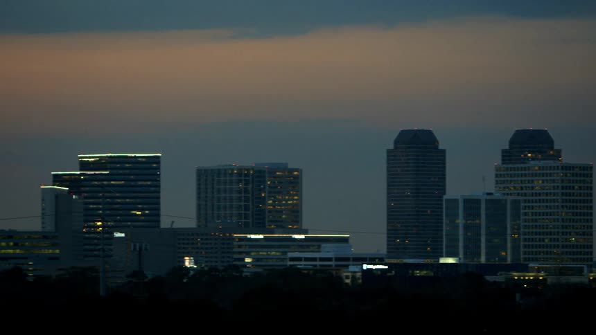 Viewing a city with lit buildings at sunset