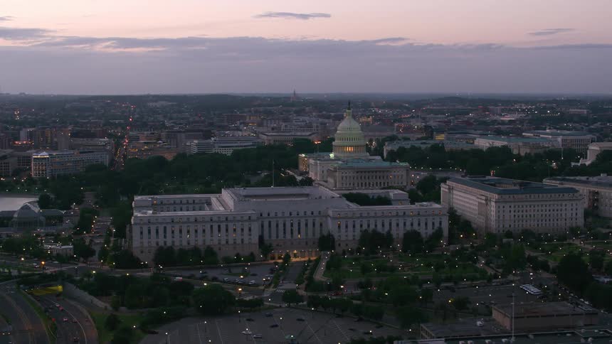 A government building in a city at sunset