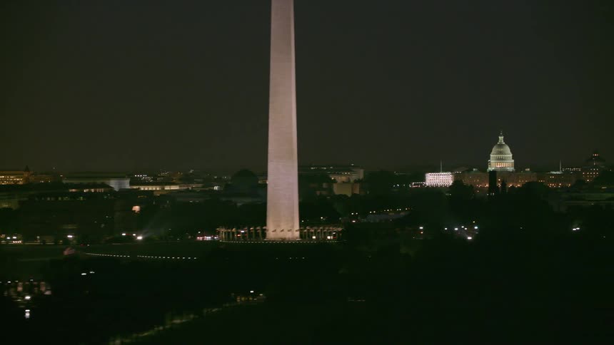 The washington monument and the capitol building in washington dc are lit up at night