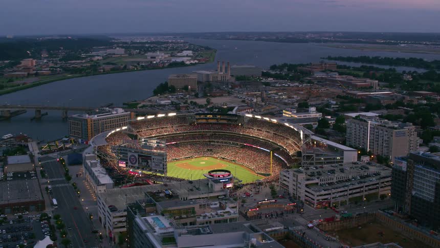 Large crowd fills stands at baseball stadium set near river at night