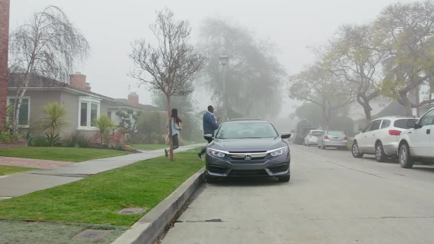 Man and woman are walking out of their house towards their car