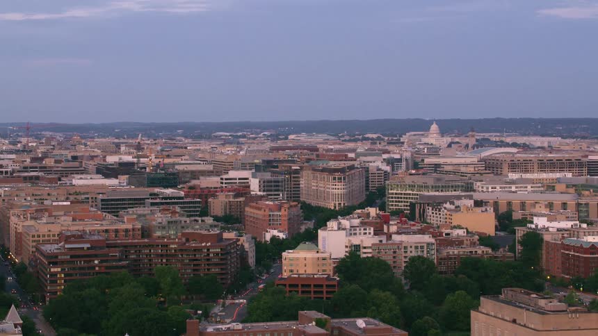 Aerial view of apartment buildings and distant united states capitol dome building at dusk