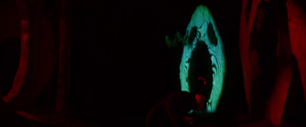 A woman performs on stage dancing and acting with lights flickering and glowing