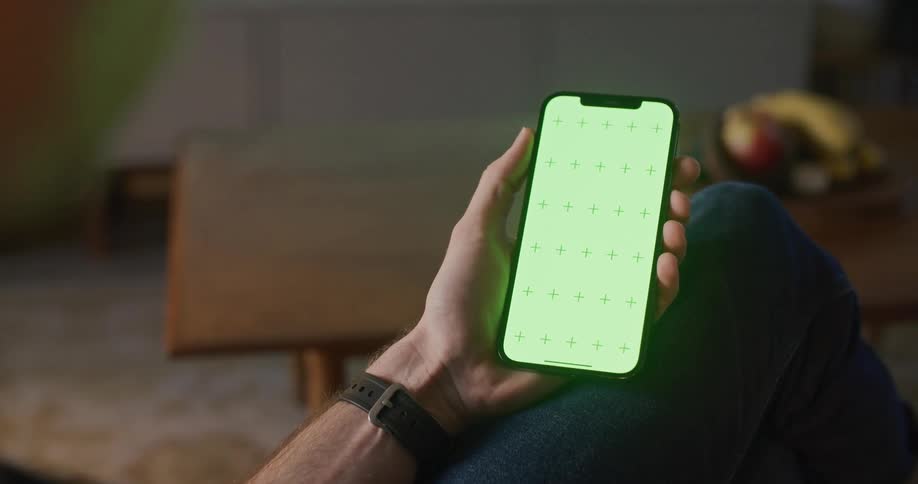 A man is sitting down holding his cell phone