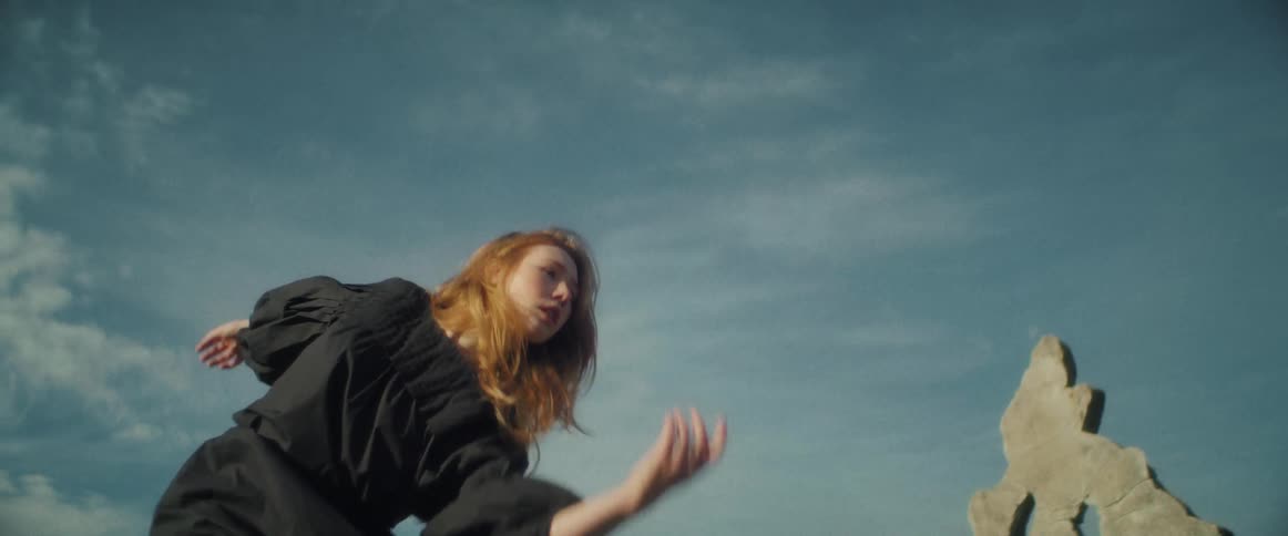 A woman is dancing outdoors during the spring time