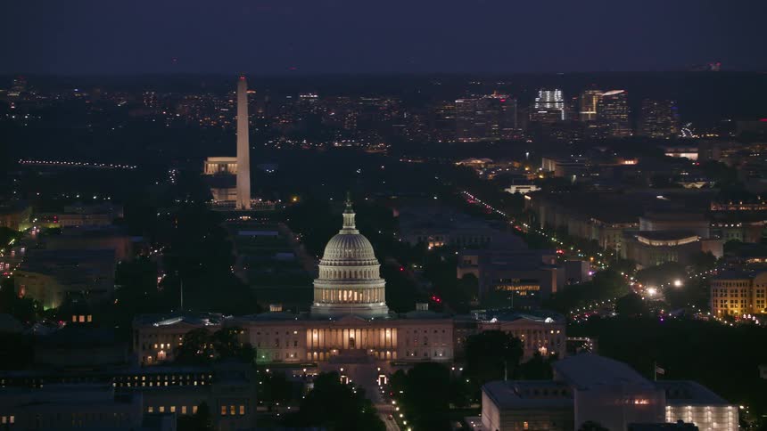 An aerial view of the white house and washington monument surrounded by buildings and vehicles driving on the streets