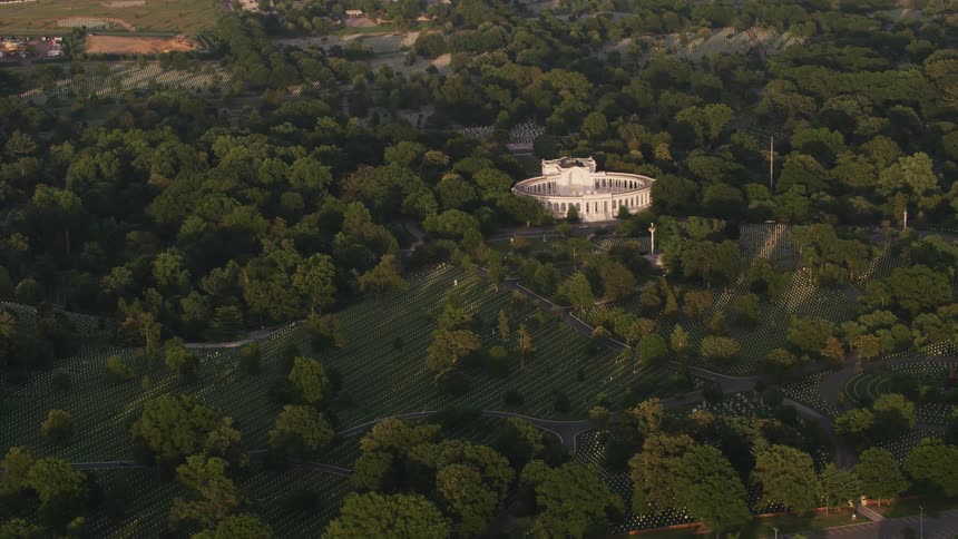 Aerial view of a building in the middle of a forest is displayed