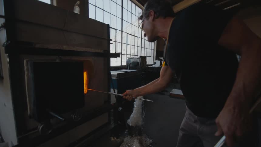 An artist firing a piece of glass to create a new work of art