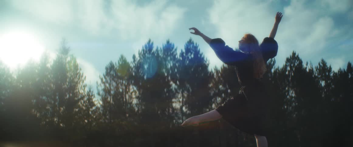 A teenager jumps as she dances outside