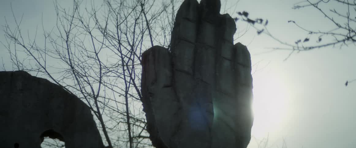 Monuments carved from wood are in a landscape area