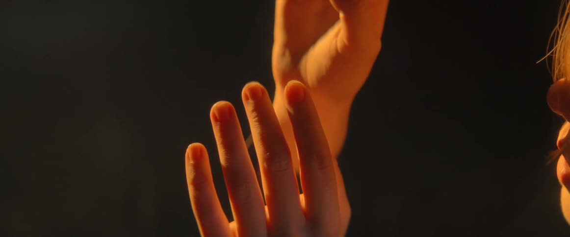 A woman is raising her arms and hands up