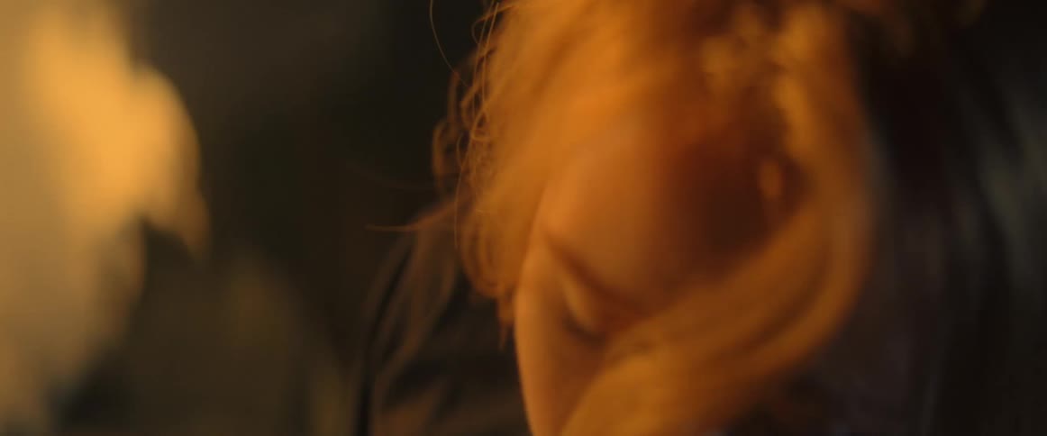 Close up of a womans face as she turns her head while the sun shines down on her